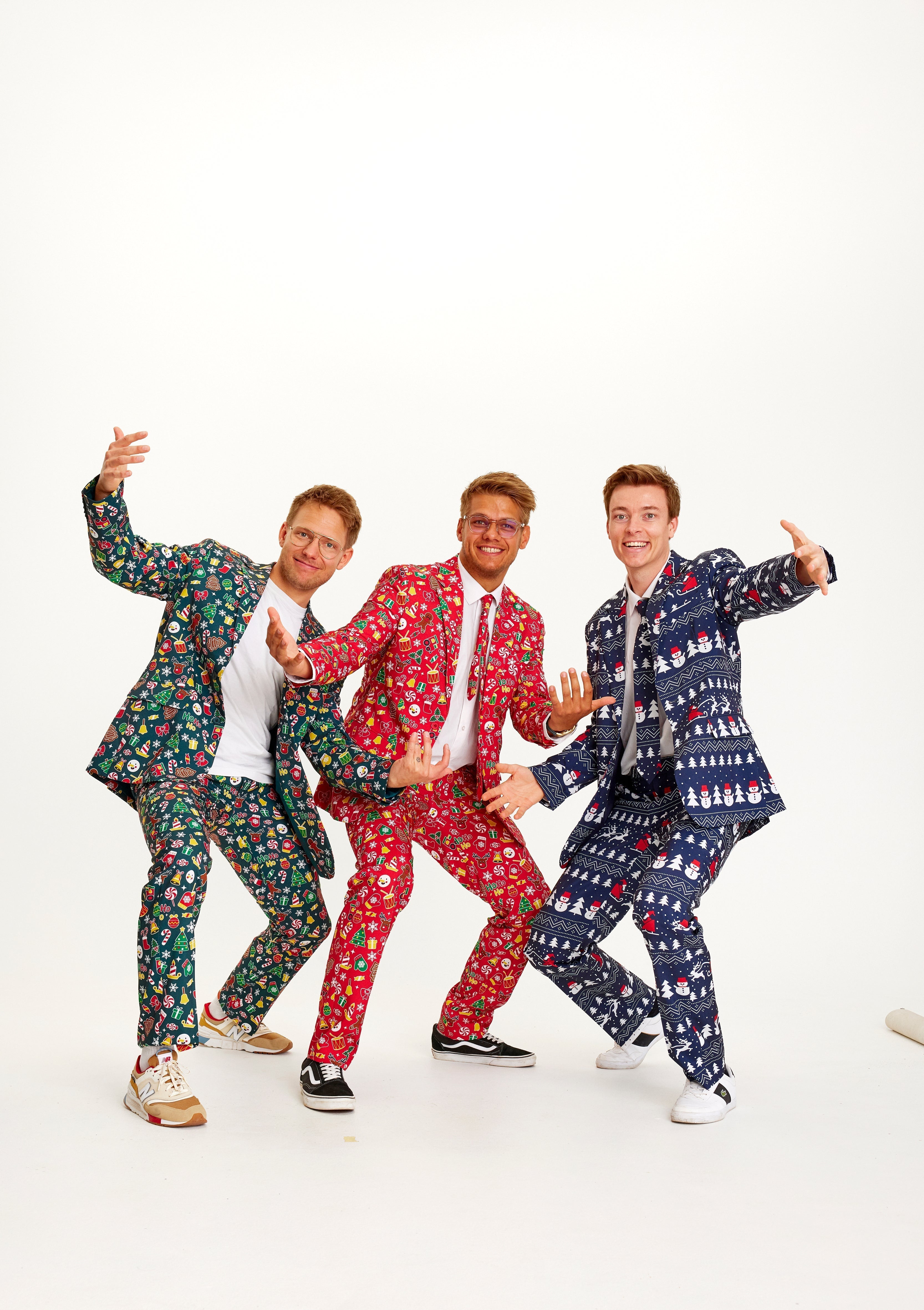 Trois hommes dansants portant chacun un costume de Noël.
